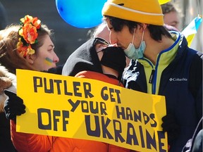 Demonstrators share a kiss at a Stand with Ukraine Against Russian Invasion rally at the Vancouver Art Gallery in Vancouver on February 24, 2022.
