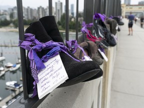Shoes with personal notes attached hung from the Burrard Bridge railing in August 2020 as part of Moms Stop the Harm's awareness-raising campaign called "Lost Soles: Gone Too Soon."