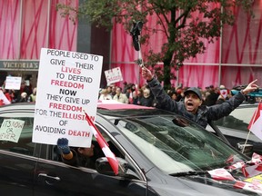 A protester yells from the car while driving down Burrard street as thousands gathered downtown in Vancouver February 5, 2022.