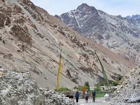 Walking between prayer flags on the way to Lower Skiu Village.