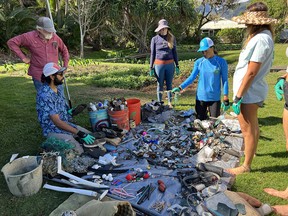 A group of volunteers examine some of the items they picked up on Maui's Ka'Ehu Beach.