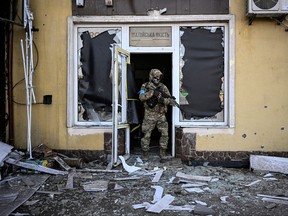 A Ukrainian serviceman exits a damaged building after shelling in Kyiv, on March 12, 2022.