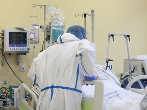 The nurse is talking with a patient who fell ill with a new type of coronavirus covid-19. Male nurse with protective coverall clothing in intensive care unit in hospital. - stock photo Credit: PatrikSlezak/

iStock/Getty Images Plus