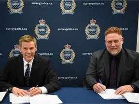 Surrey Police Chief Norm Lipinski (left) and Surrey Police Union President Rick Stewart (right) are pictured in this handout photo signing a new collective agreement reached by the Surrey Police and the Surrey Police Union, announced on Friday, March 4, 2022.