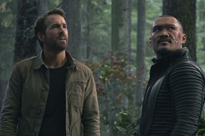Ryan Reynolds as Big Adam and Alex Mallari Jr. as Christos in a forest scene from The Adam Project.