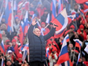 President Vladimir Putin waves during a rally marking the eighth anniversary of Russia's annexation of Crimea, at Luzhniki Stadium in Moscow, Russia, March 18, 2022.