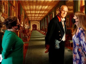 Members of the Royal Collection Trust staff pose for a photograph with the oil on canvas portrait, HRH The Prince Philip, Duke of Edinburgh, 2017, by Ralph Heimans, which forms part of the Prince Philip: A Celebration display in Windsor Castle, Britain, June 24, 2021.