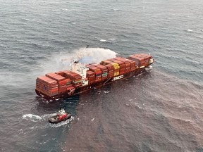 A tug pours water over the container ship Zim Kingston after it caught fire off Victoria, BC, Canada October 25, 2021.
