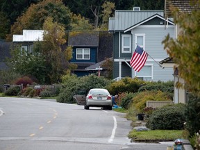 A man working in the yard outside a house in Point Roberts, Wash., is seen from Delta. Point Roberts sits on a peninsula and is only accessible by land by travelling through Canada. Photo: Darryl Dyck/CP