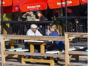 People on a curbside patio on Commercial Drive.