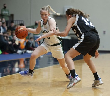 Langley Christian Lightning's Sydney Bradshaw tries to drive the ball downcourt while being guarded by St. Michaels University School Blue Jags' Avery Geddes.