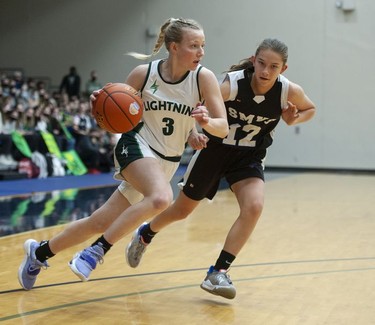 Langley Christian Lightning's Sydney Bradshaw tries to drive the ball downcourt while being guarded by St. Michaels University School Blue Jags' Avery Geddes.