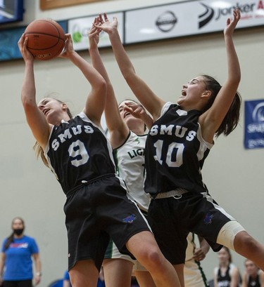 St. Michaels University School Blue Jags' Brianna McLeish (left) and Sophie Olcen fight for a rebound against Langley Christian Lightning.