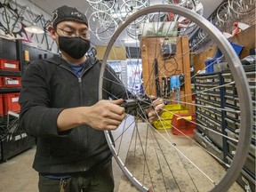 Cavan Hua, volunteer coordinator and mechanic at Our Community Bikes, works on a bicycle at 2429 Main St. in Vancouver on March 18.