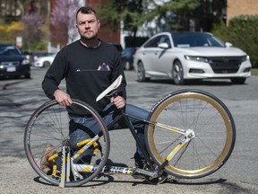 Ben Bolliger holds his broken bicycle recently at Willow Street and West 7th Avenue in Vancouver, where he was hit by a young driver behind the wheel of a Mercedes last July.
