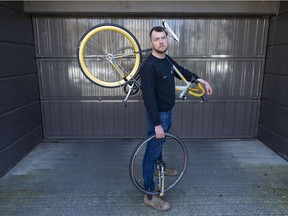 Ben Bolliger holds his broken bicycle Wednesday, March 30, 2022 near where he had a collision with a car at Willow Street and W. 7th Ave., in Vancouver last July.