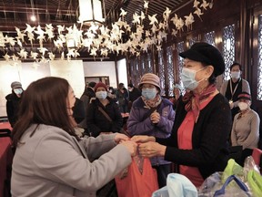 Wang Zhao (right) gets an extra present on this, her 70th birthday: Some groceries that are part of a new outreach program in Chinatown that provides seniors with culturally appropriate fresh produce.