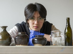 Queena Li with some of the historic glassware and bottles she helped recover and catalogue for the PoCo Heritage Museum and Archives, items that date back more than 100 years and used by Chinese labourers in early industrial Canada. ‘I speak Mandarin, and I looked into the bottles and transcribed the characters and interpreted and translated them,’ says Li, a Grade 10 student.