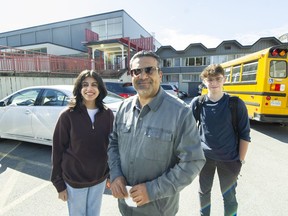 Vik Khanna, a parent and vice-chairman of the Vancouver District Parent Advisory Council, with daughter Reya and friend Spencer Izen, who writes for the school's newspaper The Griffins' Nest, outside Eric Hamber Secondary School in Vancouver on March 28.