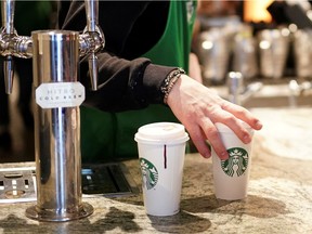 FILE PHOTO: A barista serves beverages in single use cups inside a Starbucks in London, Britain, March 6, 2020. REUTERS/Henry Nicholls/File Photo