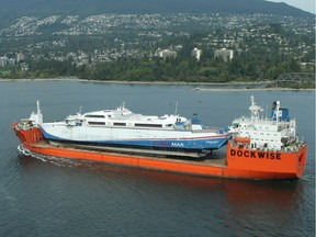 One of the fast ferries — B.C.-built, overbudget and impractical as ferries — is hauled away in 2009 after being sold essentially for scrap.