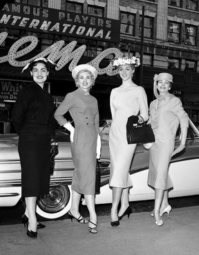 Vier Frauen vor einem Auto (Osterparade) und dem International Cinema, 1958, aus einer Fotoausstellung von Dick Oulton in der Presentation House Gallery.