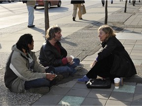 Judy Graves, the city’s former advocate for the homeless, talks with homeless men Smiley (left) and Dave on Broadway in Vancouver in 2011.