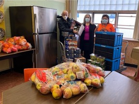 Bonnie Wendt (right) receiving food and a fridge at Vancouver's Killarney Secondary where she was single-handedly trying to feed hungry students. The fridge was provided by David McCann (left) and the food by Lisa Martella of A Loving Spoonful Meals Society (centre). The Vancouver law firm Nathanson Schachter and Thompson sent her $10,000 through Adopt-A-School.