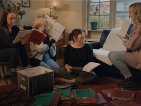 A guiding force in the creation of the new documentary Doug and the Slugs and Me were lead singer and songwriter Doug Bennett's journals. Seen are, from left, Della Bennett, Shea Bennett, filmmaker Teresa Alfeld and Devon Bennett going over some of the 39 books Doug Bennett filled between 1980-89.