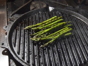 Cooking asparagus on a skillet.