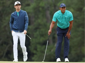 Joaquin Niemann of Chile (L) and Tiger Woods looks on from the 18th green during the second round of The Masters at Augusta National Golf Club on April 08, 2022 in Augusta, Georgia.