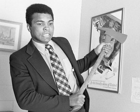 Boxing Muhammad Ali's great faces with a fire ax in front of cameras at the Vancouver airport, April 21, 1972. Ralph Bower/Vancouver Sun