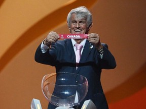 Former Serbian footballer Bora Milutinovic displays the name of Canada during the draw for the 2022 World Cup in Qatar at the Doha Exhibition and Convention Center on April 1, 2022.