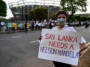 Protesters hold banners and placards during a demonstration against the surge in prices and shortage of fuel and other essential commodities in Colombo on April 2, 2022.