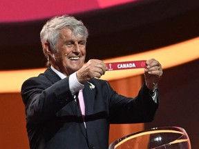 Former Serbian footballer Bora Milutinovic holds the card showing the name of Canada during the draw for the 2022 World Cup in Qatar at the Doha Exhibition and Convention Center on April 1, 2022.