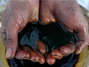 An employee holds a sample of crude oil at the Yarakta oilfield, owned by Irkutsk Oil Co, in the Irkutsk region, Russia on March 11, 2019. REUTERS/Vasily Fedosenko