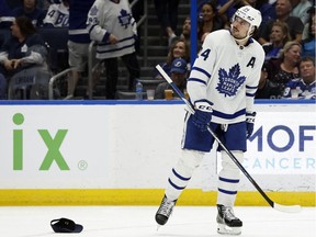 Auston Matthews looks at his clock with a score next to his hat on ice after the Maple Leafs star scored his hat-trick against the Tampa Bay Lightning on Monday in Tampa, Florida.