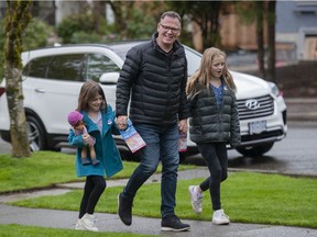 Kevin Falcon with his daughters Rose, 9 (left) and Josephine, 12, knocked on the door in Vancouver on Saturday, April 30, 2022.