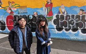 Artists Sean Cao and Katharine Yi in front of their mural, which was vandalized in Chinatown, in this photo from March 27, 2022.