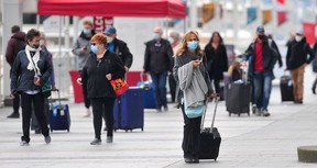 Passengers disembark from The Koningsdam cruise ship at Canada Place in Vancouver on April 10, 2022.