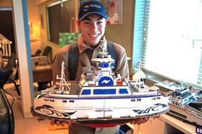 Joshua Jung holds up a replica of the ferry he built at school.  Joshua Jung, who was diagnosed with autism at 15, built his own fleet of ferries using household items including cardboard, toothpicks and straws for school projects.  Joshua works as a sailor for BC Ferries.