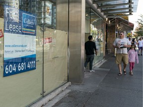Pedestrians walk past an empty a storefront on Robson Street in Vancouver, BC, September, 6, 2020.