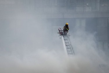 CP-Web. A firefighter on a ladder truck directs water on a four-alarm fire burning at a single room occupancy (SRO) hotel, in Vancouver, B.C., Monday, April 11, 2022. Vancouver's fire chief says some people remained unaccounted for as crews fought a fire inside a four-storey residential building in the city's Gastown neighbourhood. THE CANADIAN PRESS/Darryl Dyck ORG XMIT: VCRD103_2022041122