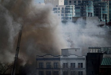 CP-Web. A firefighter on a ladder truck directs water on a four-alarm fire burning at a single room occupancy (SRO) hotel, in Vancouver, B.C., Monday, April 11, 2022. Vancouver's fire chief says some people remained unaccounted for as crews fought a fire inside a four-storey residential building in the city's Gastown neighbourhood. THE CANADIAN PRESS/Darryl Dyck ORG XMIT: VCRD107_2022041122