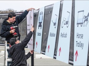 Michel Ward and Rob Marshall with Graphic FX put up signs at Ogden Point in preparation for the first cruise ship of the season, arriving Saturday.