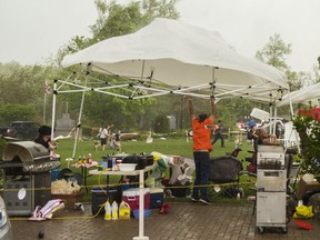 Volunteers at the first annual Log Drivers Festival in Marmora scramble to hold a gazebo from blowing away during Saturdays storm which swept through parts of Ontario leaving at least four people dead.