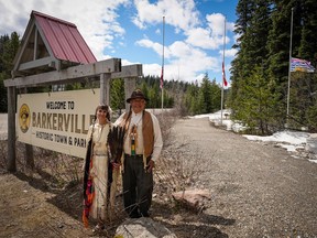 Indigenous interpreters Mike Retasket and Cheryl Chapman with the three flags about to be retired at Barkerville in commemoration of residential school victims. Photo: James Douglas.