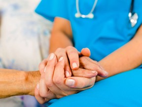 FILE PHOTO: A nurse holding a patient's hand.