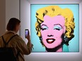 A woman takes a photo of Andy Warhol's 'Shot Sage Blue Marilyn' during Christie's 20th and 21st Century Art press preview at Christie's New York on April 29, 2022 in New York City.