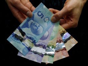 Canadian five and 10 dollar bills are displayed at the Bank of Canada in Ottawa April 30, 2013.